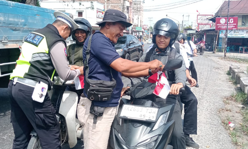 In Celebration of Indonesia’s 80th Independence Day, Kualuh Hulu Police Distribute and Install National Flags Along Aek Kanopan Highway